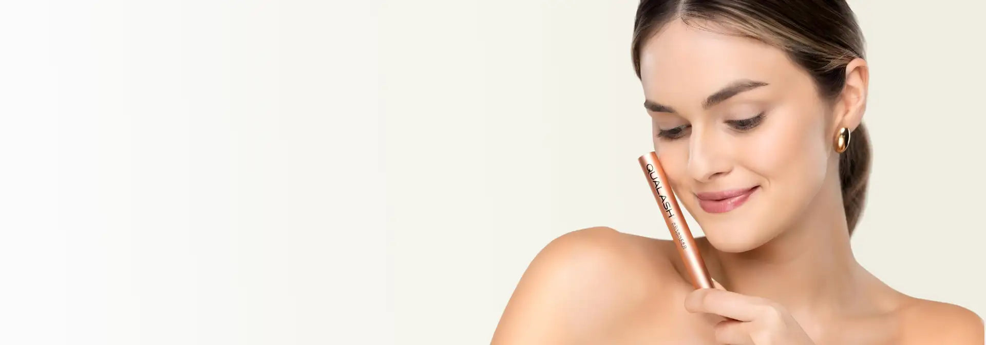 A sleek, rose-gold metallic eyeliner pencil with a smooth, tapered tip and minimalist branding.